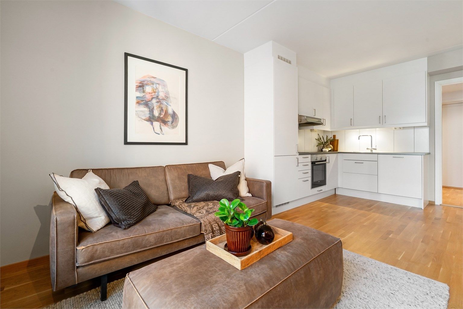 Den åpne løsningen mellom stue og kjøkken skaper en sosial og luftig atmosfære.