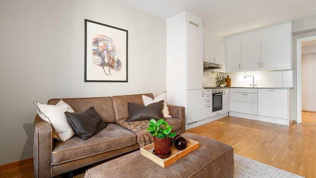 Den åpne løsningen mellom stue og kjøkken skaper en sosial og luftig atmosfære.