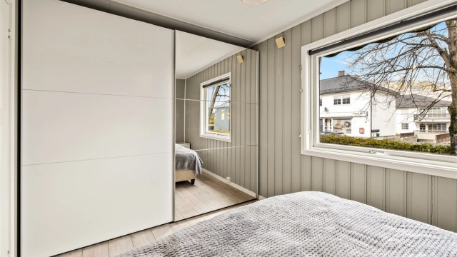 En romslig skyvedørsgarderobe med speilfronter gir rikelig med oppbevaringsplass.