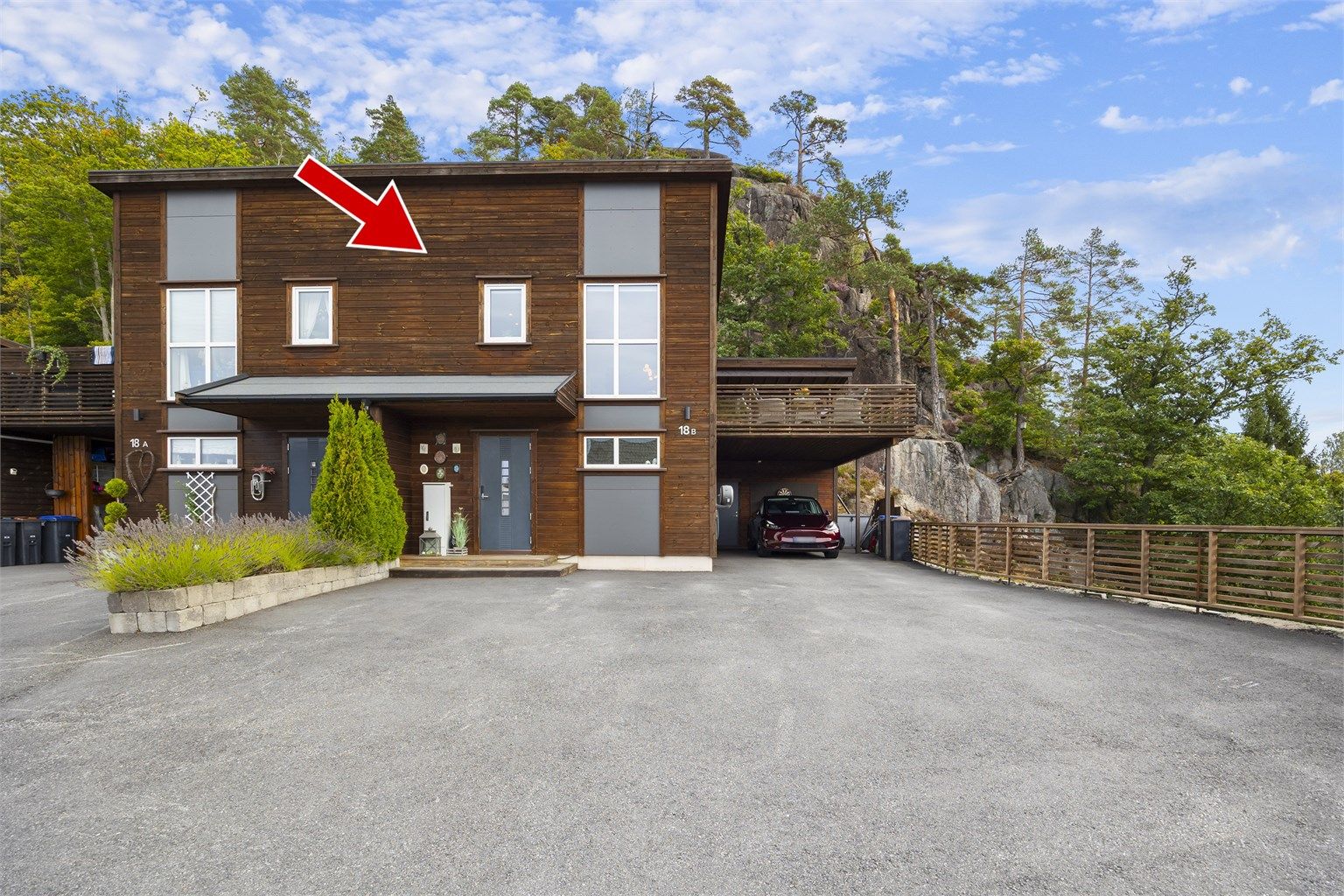 Eiendommen ligger i en blindvei med asfaltert gårdsplass og carport direkte ved inngangen.