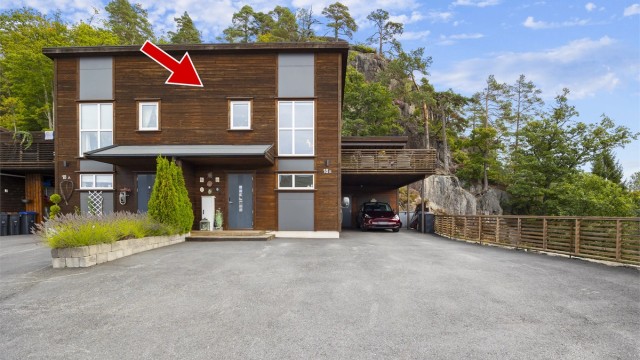 Eiendommen ligger i en blindvei med asfaltert gårdsplass og carport direkte ved inngangen.