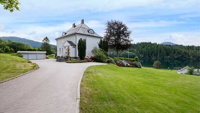 Eiendommen ligger tilbaketrukket og privat, med en lang og innbydende innkjørsel