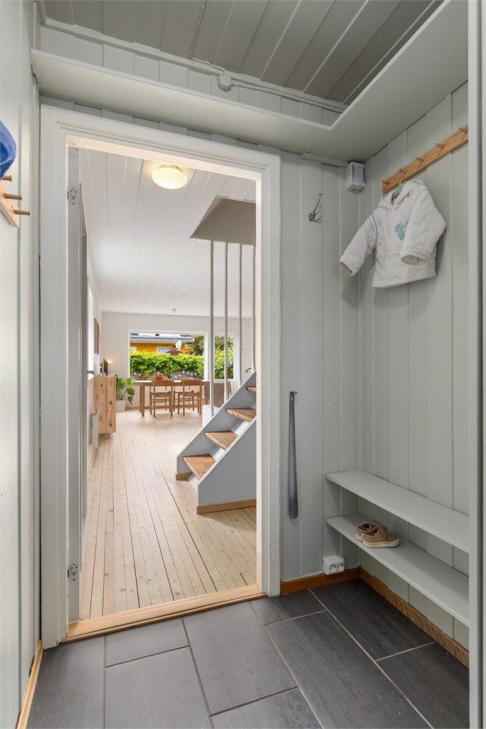 Entré med flislagt gulv med gulvvarme, samt hyller og knagger til å sette fra seg sko og henge fra seg yttertøy
