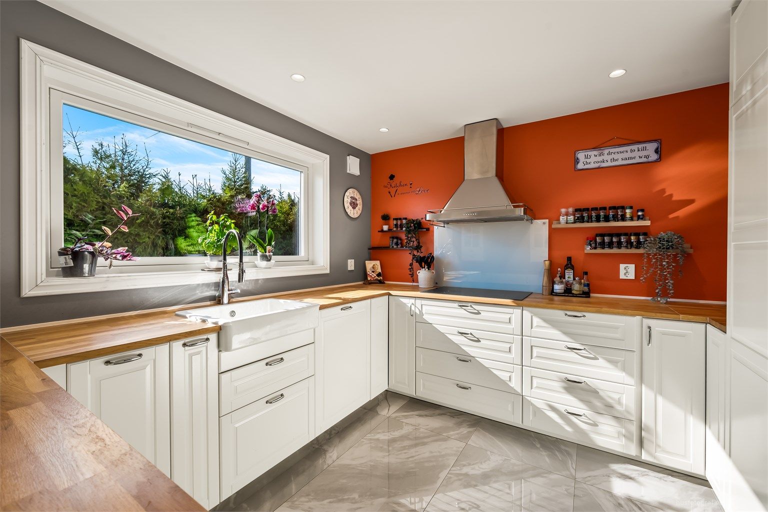 Stor porselensvask, benkeplate i heltre og den luftige løsningen med mye skapplass gir kjøkkenet et landlig preg.