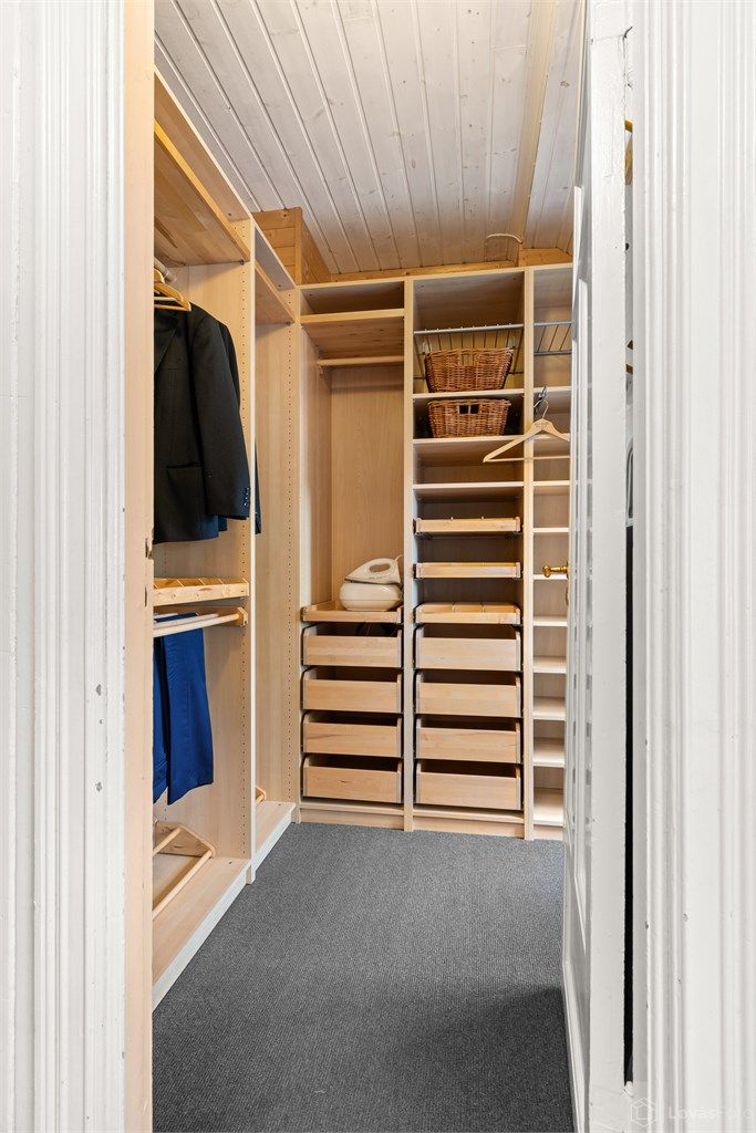 Praktisk walk-in closet med rikelig hylle- og hengeplass.
