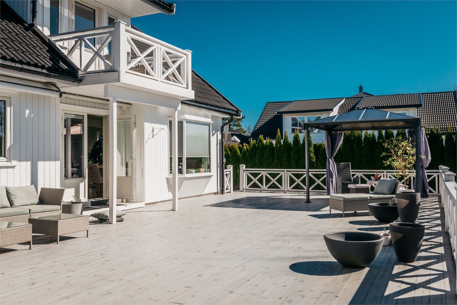 Den svært romslige terrassen gir rikelig med plass for både sittegrupper, spisebord og grill.