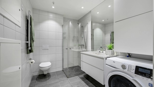 Lyst og trivelig bad med flislagte gulv og vegger, det er elektriske varmekabler i gulv.