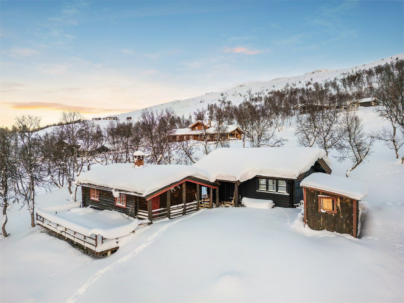 Tomta ligger høyt og fint i terrenget, omgitt av et vakkert fjellandskap. 