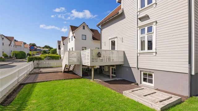 Solrik tomt med både gressplen, terrasser ,sandkasse til de små.