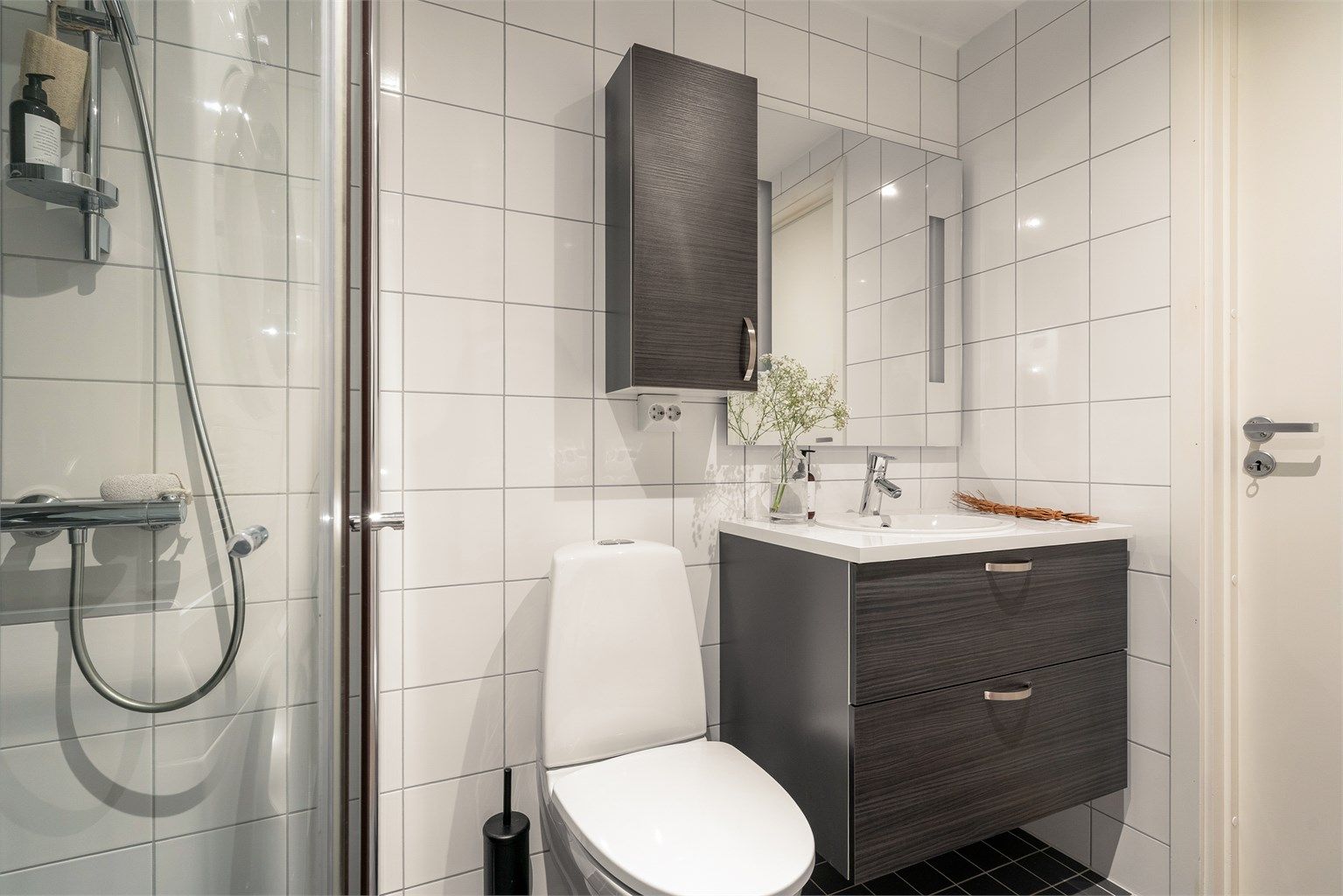 Baderomsinnredning fra HTH, vegghengt klosett for enklere renhold og praktiske dusjvegger i glass.