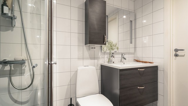 Baderomsinnredning fra HTH, vegghengt klosett for enklere renhold og praktiske dusjvegger i glass.