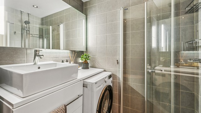 Badet er utstyrt med vegghengt toalett, dusjhjørne med innfellbare dører og opplegg for vaskemaskin.