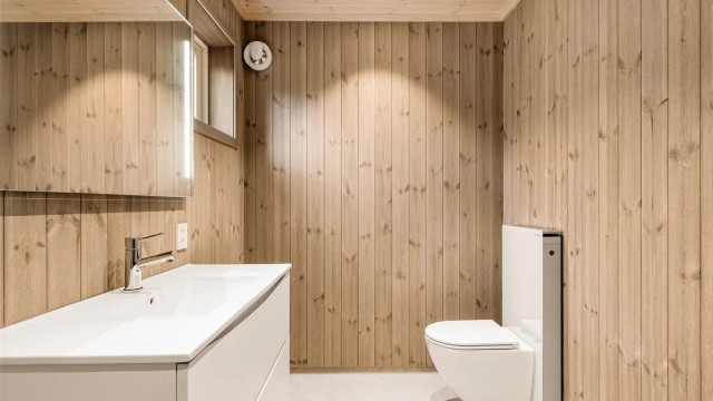 Badet er enkelt og tidløst, flisene med gråsjattering står fint til den enkel baderomsinnredningen.