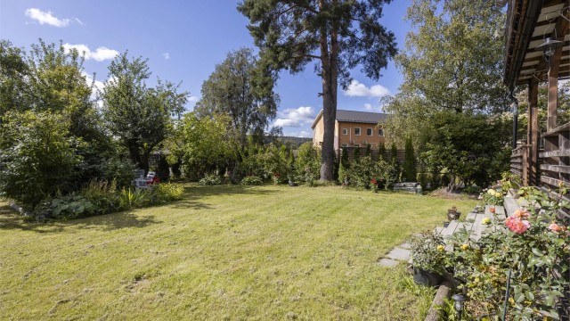 Hagen er pent opparbeidet med flott beplantning som gjør en hagen er fint skjermet mot trafikk.