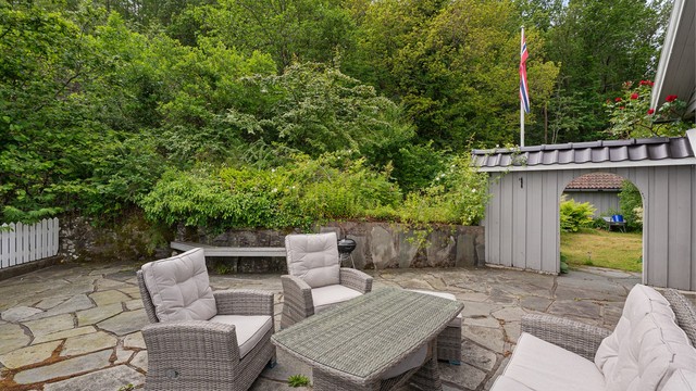 Videre fra hagen bak huset finner du en lun og romslig del av hagen lagt med stein