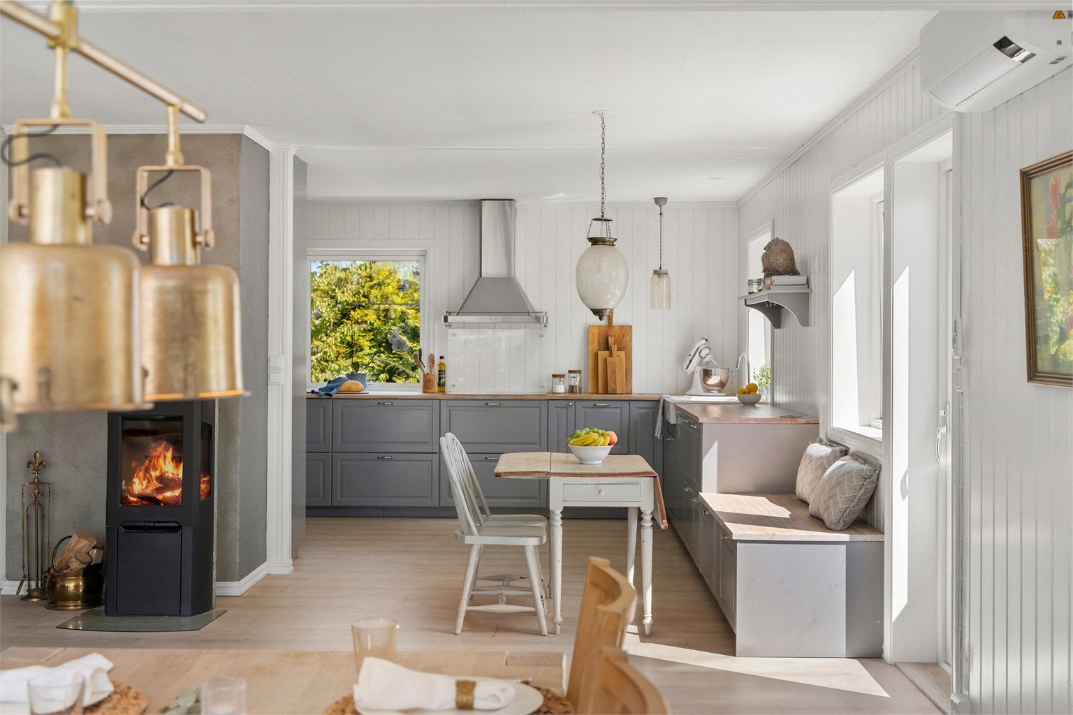 Delvis åpen løsning inn til kjøkkenet, med koselig benk som en forlengelse av kjøkkeninnredningen 