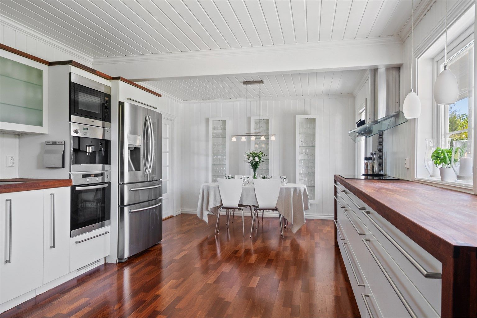 Benkeplaten er i varmbrunt heltre, som er trukket ned langs sidene på benken. I tillegg har veggskapene fått en matchende ramme.