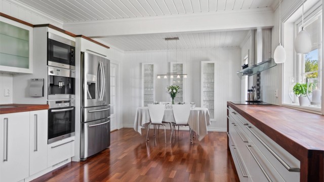 Benkeplaten er i varmbrunt heltre, som er trukket ned langs sidene på benken. I tillegg har veggskapene fått en matchende ramme.