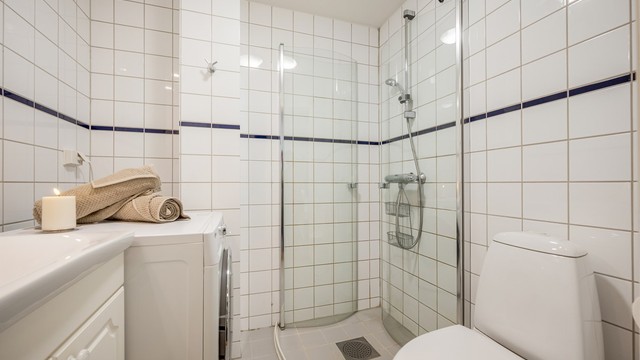 Rommet er utstyrt med klosett, servant med innredning og dusjhjørne med svingbare glassdører, samt opplegg for vaskemaskin. Ventilasjonen ivaretas av mekanisk avtrekk.