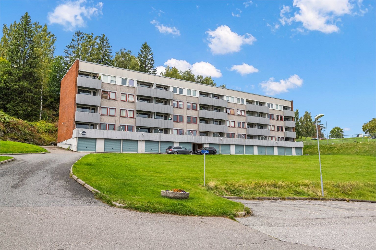 Bygget ligger fritt og luftig til med store plenarealer rundt eiendommen.