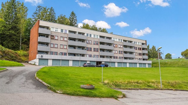 Bygget ligger fritt og luftig til med store plenarealer rundt eiendommen.