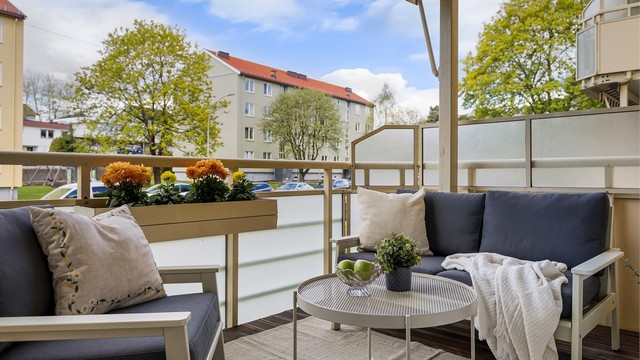Tilfarer av tre med terrassebord. Rekkverk av stålkonstruksjoner med frostede glassfelt. Rekkverkshøyden ble målt til: 1,02 m. Elektrisk markise over balkongen