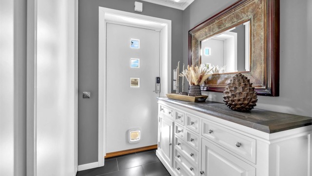 Du blir ønsket velkommen i en fin entré med grå fliser på gulv med gulvvarme. Her er det godt med plass for å henge fra deg ytterklær og sko, samt godt med lagringsplass i montert skyvedørsgarderobe.