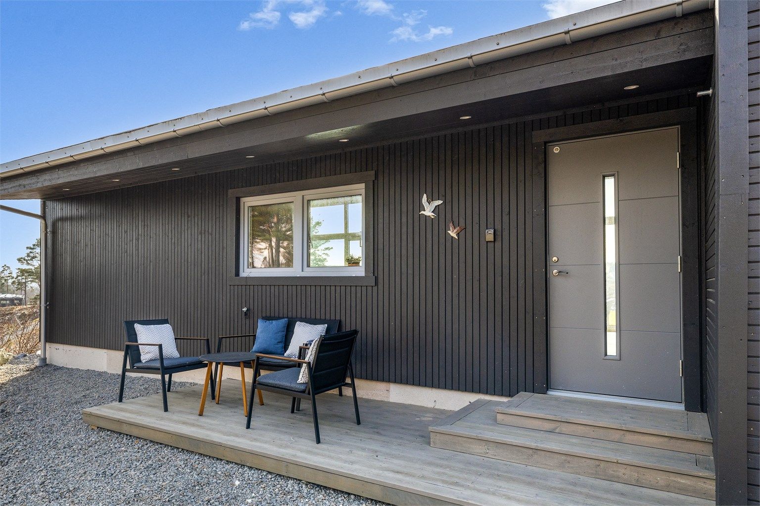 BAKSIDE MED STIL: Fra inngangspartiet ser du tvers gjennom hytta og ut mot sjøen. Her er det også anlagt en liten terrasse for morgensolen.