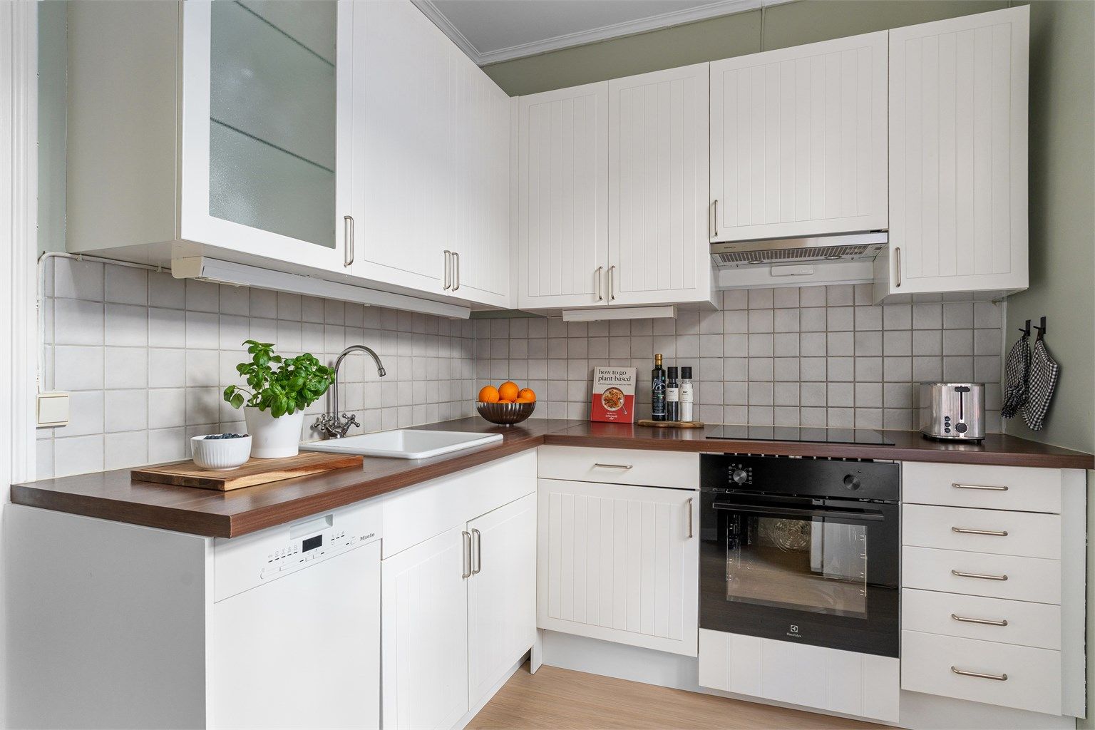 Videre inn i kjøkkenet, finner vi en tidløs innredning med profilerte fronter. 