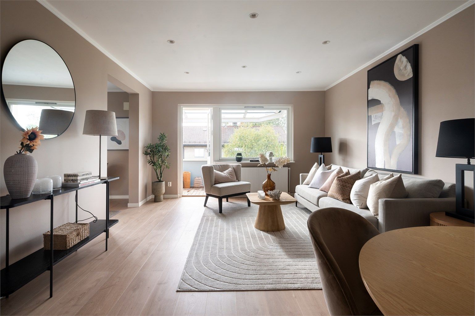 Det er store vindusflater som slipper inn rikelig med lys og som bidrar til å skape en luftig følelse i leiligheten. 