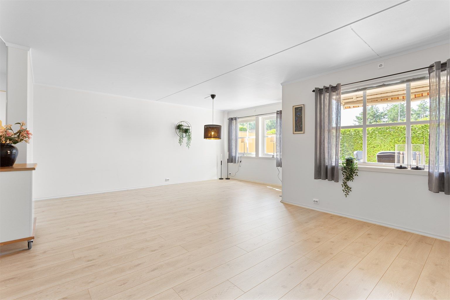 Lys stue med plass til sofagruppe og spisebord - nyere gulver og lyse vegger