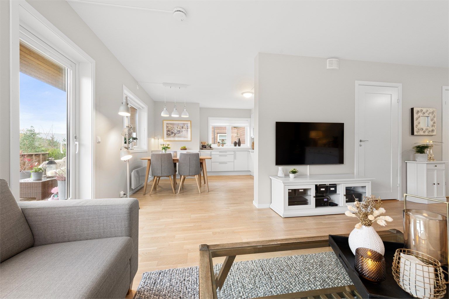 Leiligheten fremstår med gjennomgående moderne uttrykk, store vindusflater og rene linjer