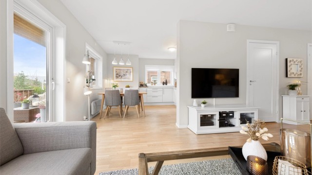 Leiligheten fremstår med gjennomgående moderne uttrykk, store vindusflater og rene linjer