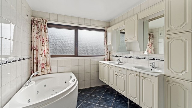 Badet er utstyrt med badekar, dusjkabinett, bidé, innredning med doble servanter og elektrisk gulvvarme.