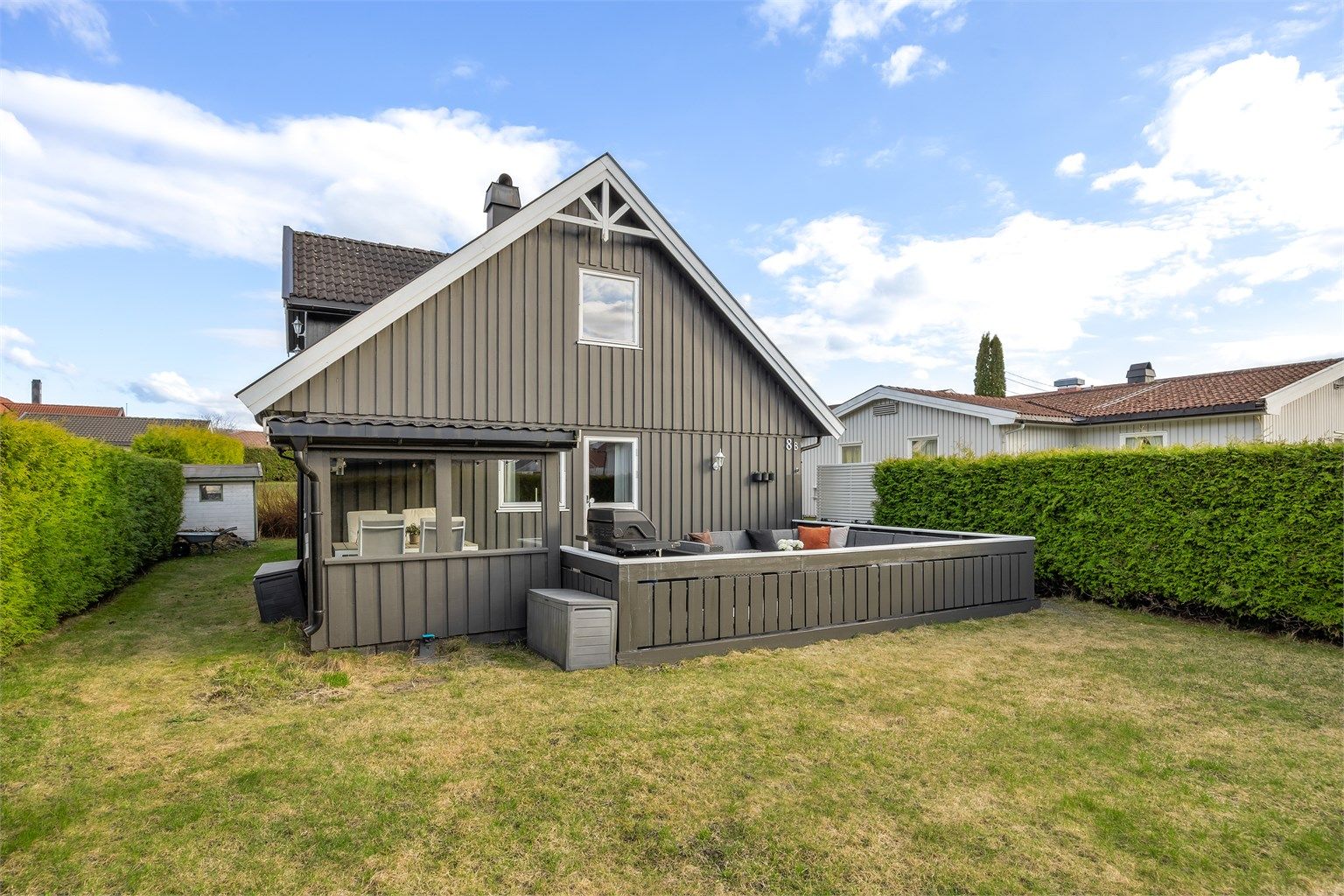 Tomten er tilnærmet flat og pent opparbeidet med plenarealer og beplantning.