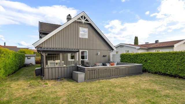 Tomten er tilnærmet flat og pent opparbeidet med plenarealer og beplantning.