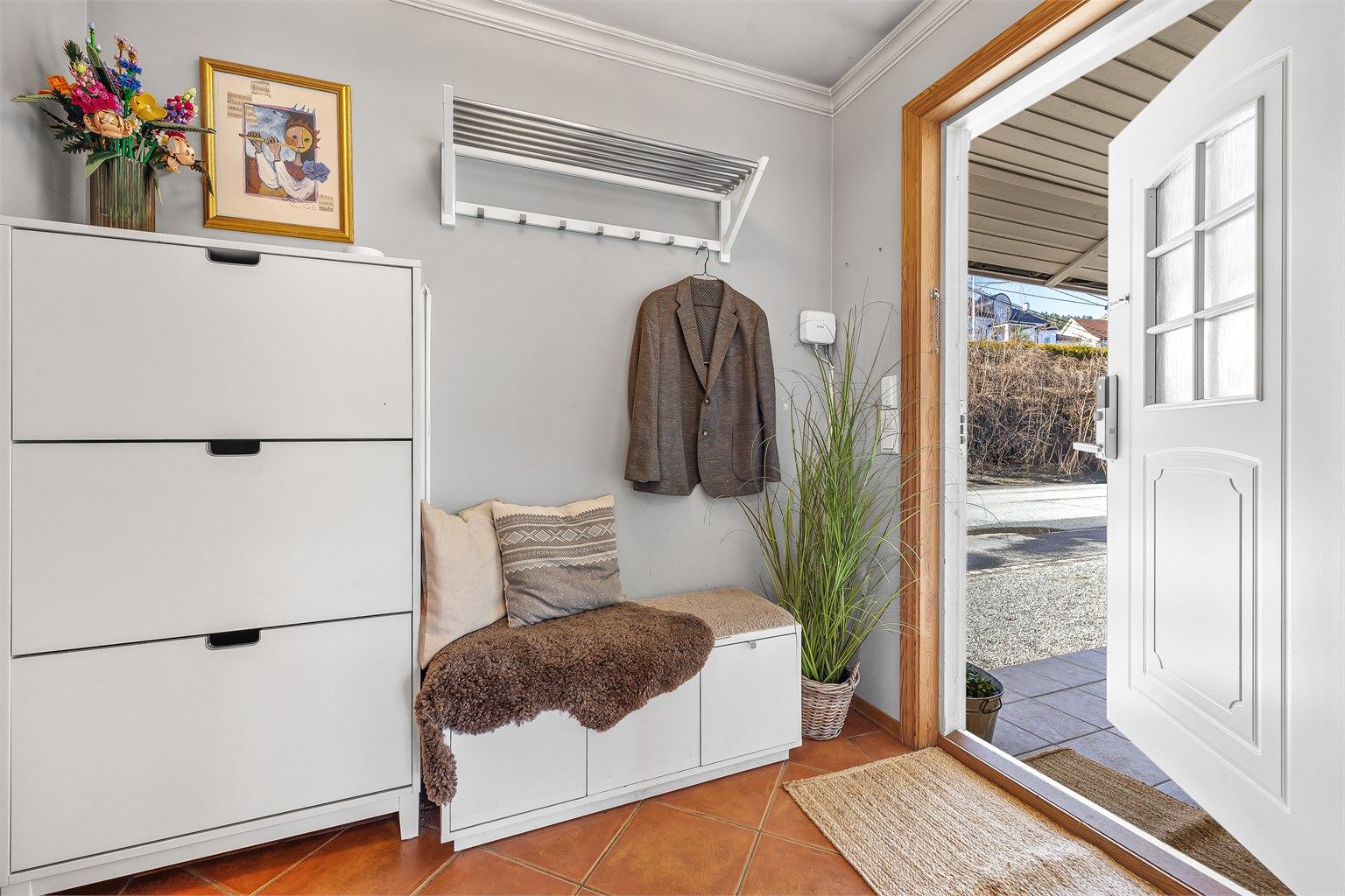 Innbydende entré med plass til oppbevaring av yttertøy og sko. Ytterdøren har elektronisk kodelås.