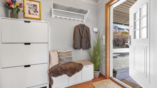 Innbydende entré med plass til oppbevaring av yttertøy og sko. Ytterdøren har elektronisk kodelås.