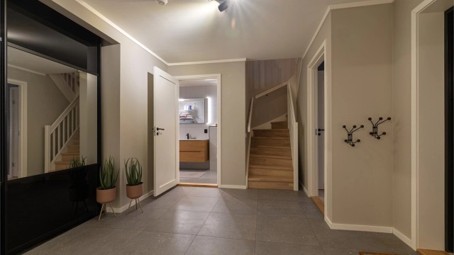 Stilfullt og gjennomgående innredet med eik- og sorte detaljer. Praktisk innvendig bod under trapp.