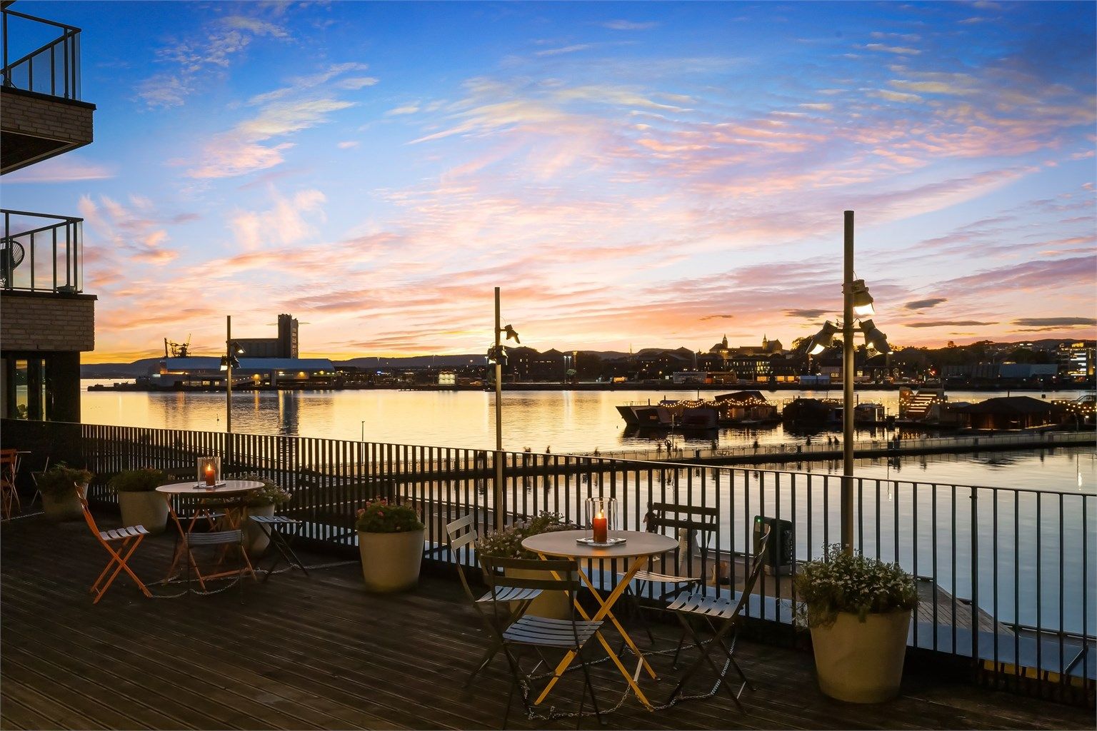 Kveldsstemning over havnebassenget og Sukkerbiten. Bilde fra sameiets private terrasse plassert et nivå over bryggegangen

Foto: Zovenfra
