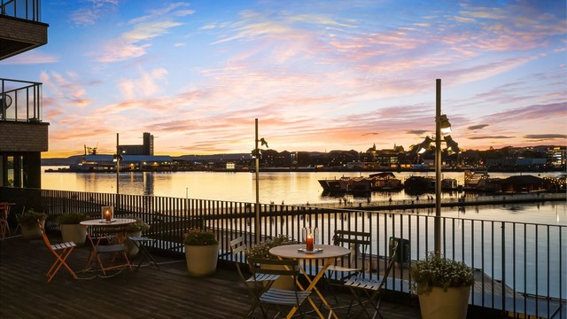 Kveldsstemning over havnebassenget og Sukkerbiten. Bilde fra sameiets private terrasse plassert et nivå over bryggegangen
Foto: Zovenfra
