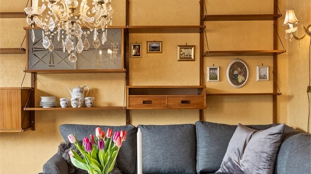 En plassbygd hylleløsning gir rikelig med oppbevaringsplass i stuen.