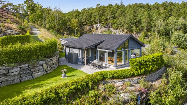 Eiendommen ligger lunt og usjenert til i hagen hvor det er strategisk plantet hekk mot endeveien.