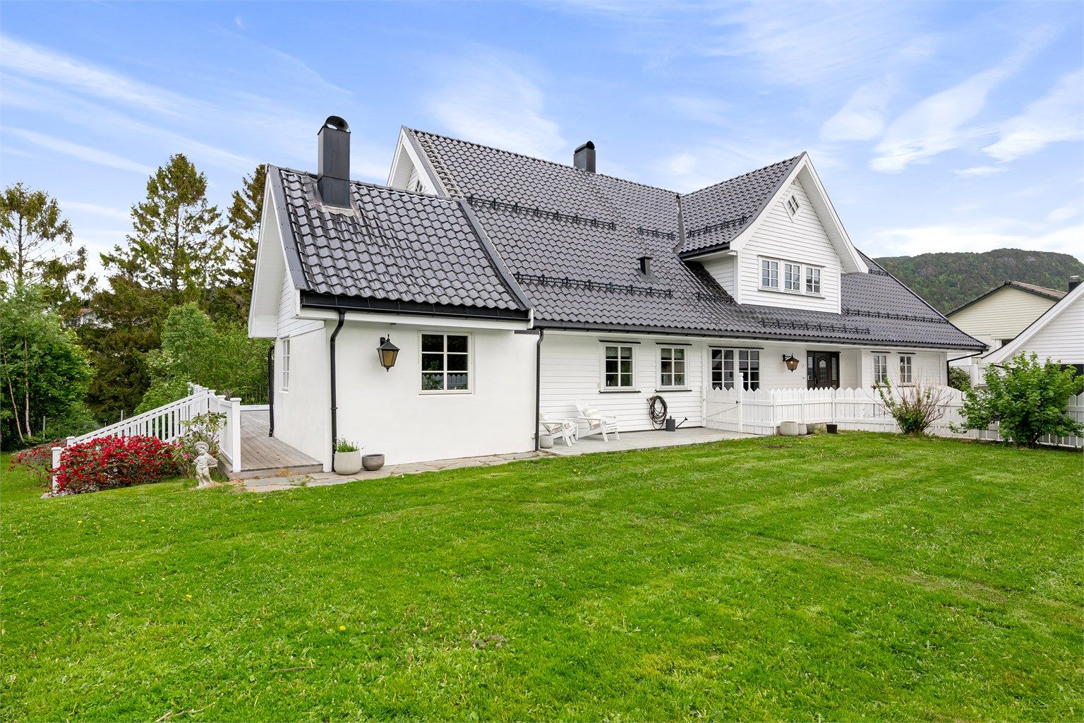 Eneboligen har liggende bordkledning og tegltakstein.