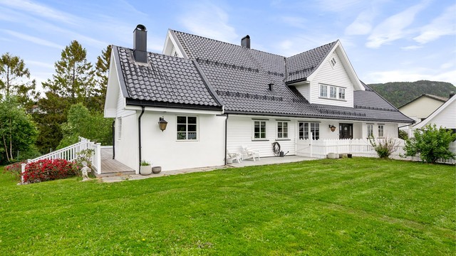 Eneboligen har liggende bordkledning og tegltakstein.
