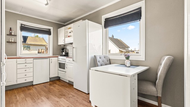 Kjøkkenet har plass til en liten spiseplass ved vinduet og er utstyrt med frittstående hvitevarer.