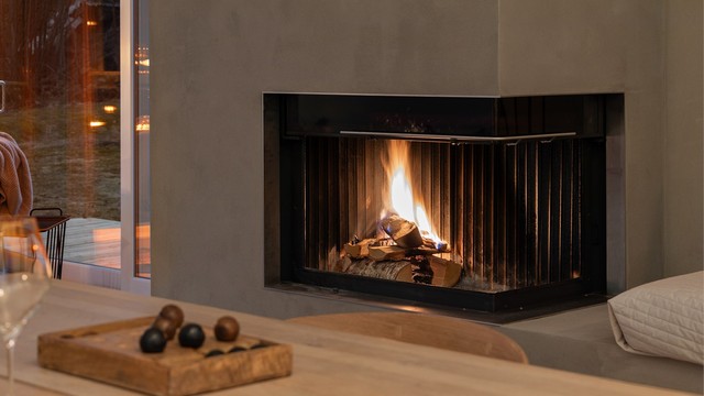 Moderne, integrert peis i stuen/spisestuen.