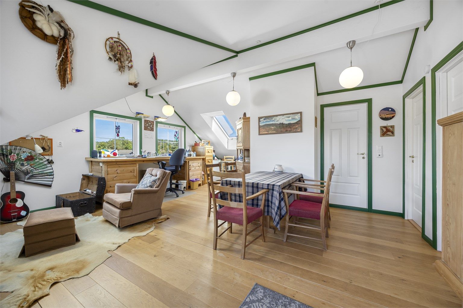 Innredet loft over garasjen med stue/hobbyrom og parkettgulv.