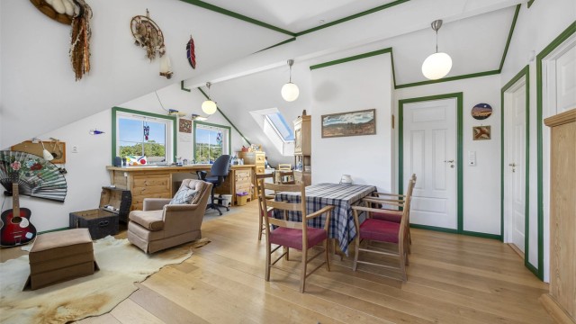 Innredet loft over garasjen med stue/hobbyrom og parkettgulv.