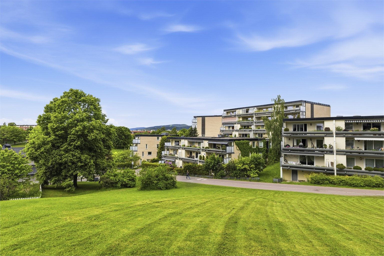Fasade. Det er flotte grøntområder rundt boligen 